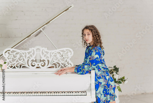 Teeager girl at the piano, classical music concept photo