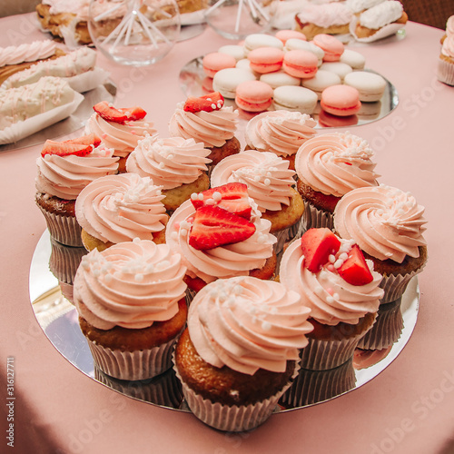 Cupcakes with pink cream and strawberries
