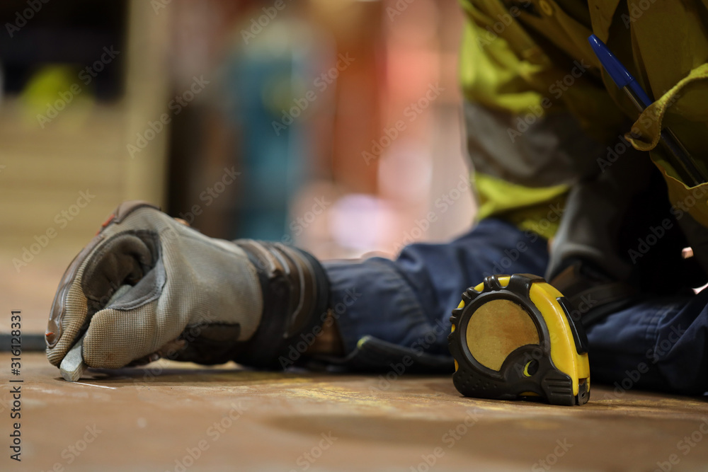 carpentry wearing a safety glove using measurement tape while working measuring material 