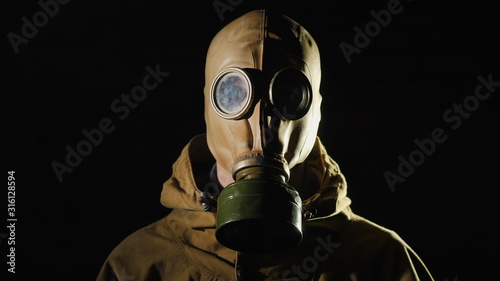 Tableau sur toile A person in a gas mask on a black background