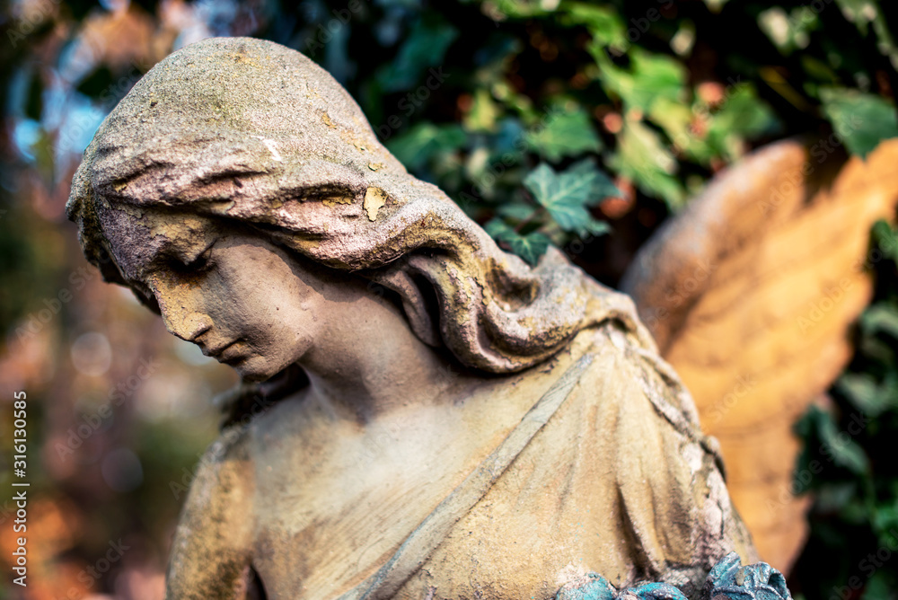 A fragment of ancient sculpture angel in the old cemetery. Symbol of love, invisible forces, purity, enlightenment, ministry, salvation. Chariot.