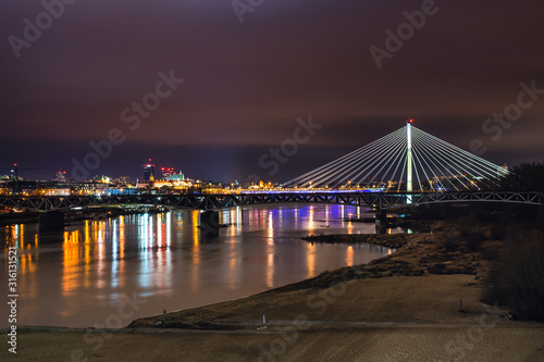Nocne zdjęcie Warszawskiego mostu Świętokrzyskiego i rzeka Wisła
