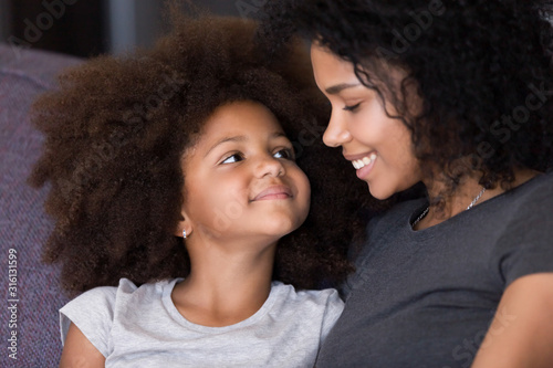 Close up of black mom and daughter hugging at home