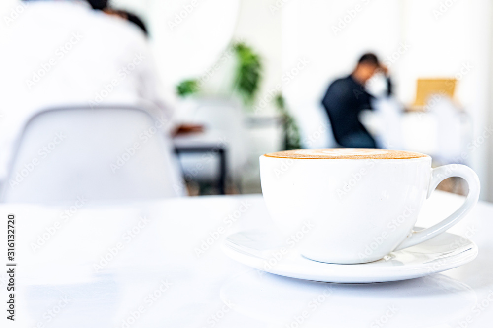 A cup of hot coffee latte on a white background at the coffee shop A cup of hot coffee latte on a white background at the coffee shop