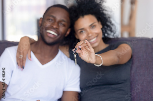 Obraz na plátně Excited black couple holding keys to first shared home