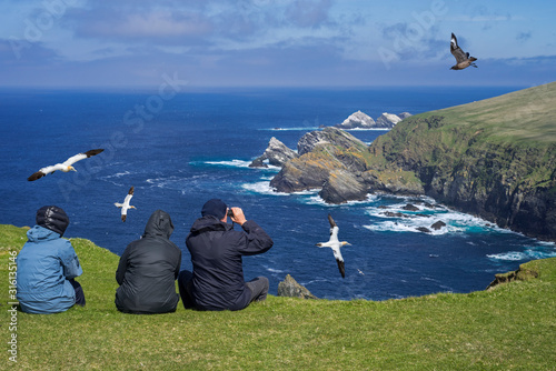 Birdwatchers watching seabirds at Hermaness, Shetland, Scotland, UK photo