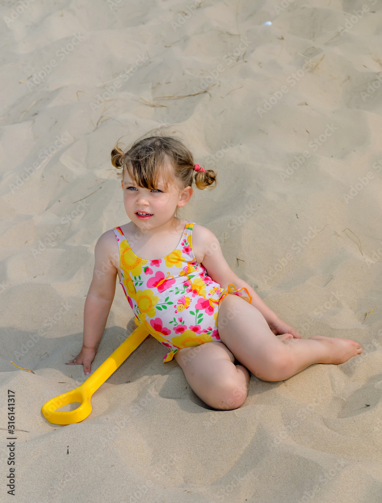 cute little girl playing on the beach Stock Photo | Adobe Stock