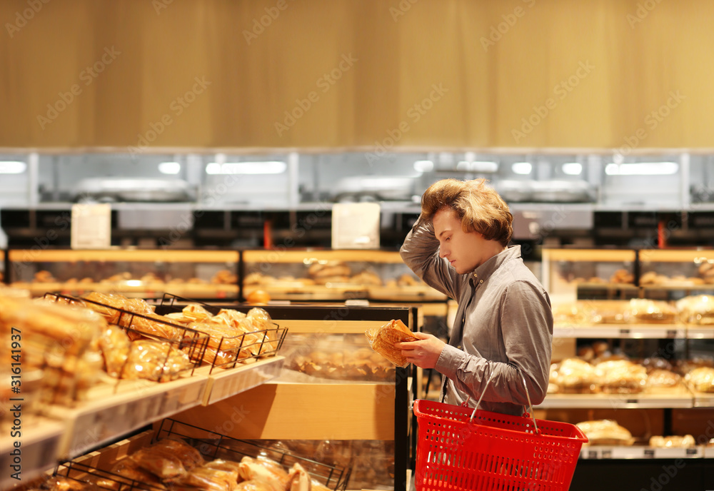 Teenager choosing bread from a supermarket	