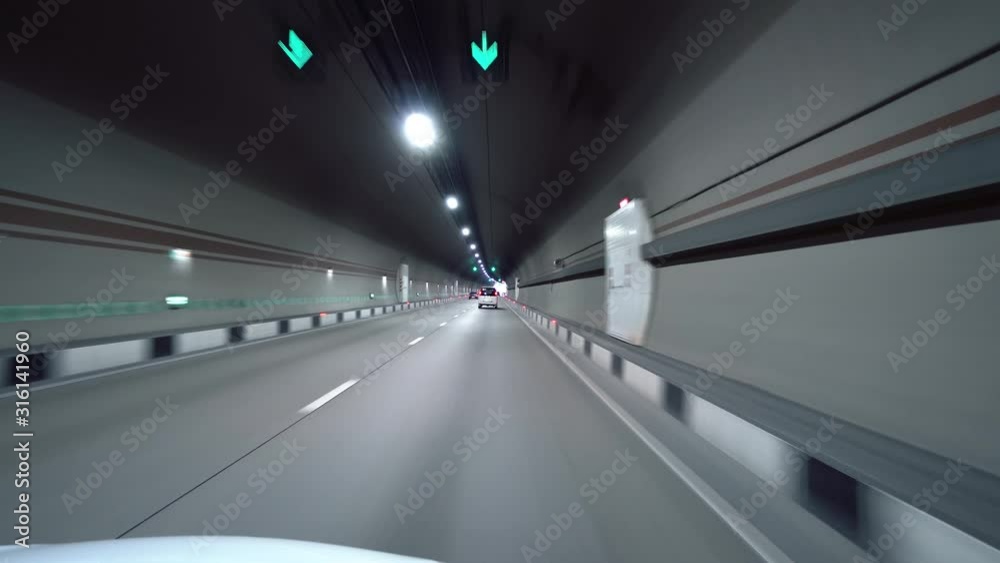 White car ride through underground tunnel road. Tube night illumination. Fast moving inside motorway mountain pass. Travel tourist bus alpine Europe Sochi. Longest tunnel car traffic technology White car ride through underground tunnel road. Tube night illumination. Fast moving inside motorway mountain pass. Travel tourist bus alpine Europe Sochi. Longest tunnel car traffic technology