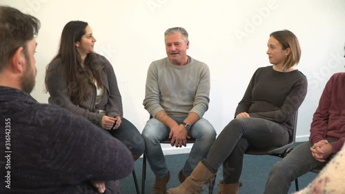 Support group people sat in circle for therapy Counselling session - One man talks while the others listen. Mental Heath, Alcoholic photo