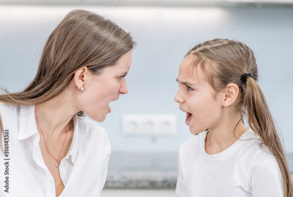 Mother and daughter shout at each other face to face. Family relationships