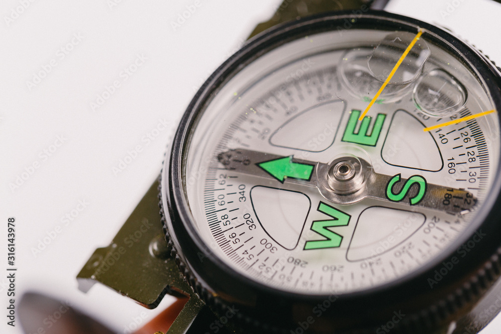 metal navigation travel compass on a light gray background. search for a way. point of view metal navigation travel compass on a light gray background. search for a way. point of view
