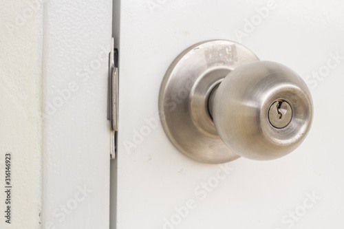 Aluminum door knob on the white door skin.