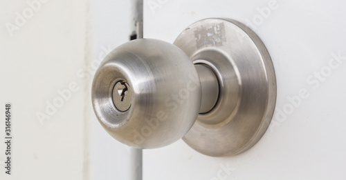 Aluminum door knob on the white door skin. photo