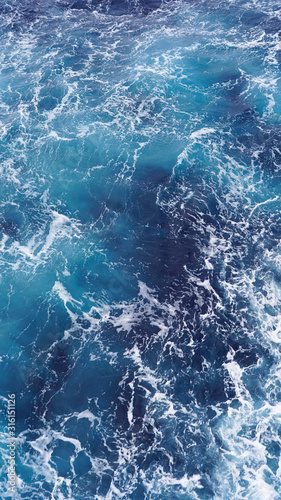 Dark water of the pacific ocean. Natural blue background. foam composition in the ocean. white sea foam  waves  storm. vertical photo