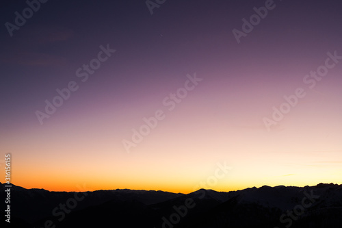 Sunset landscape with mountain chain silhouette
