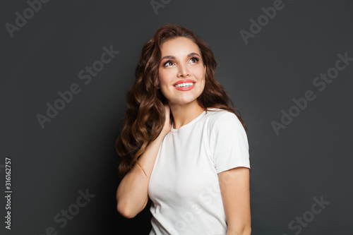 Happy woman looking up on gray background