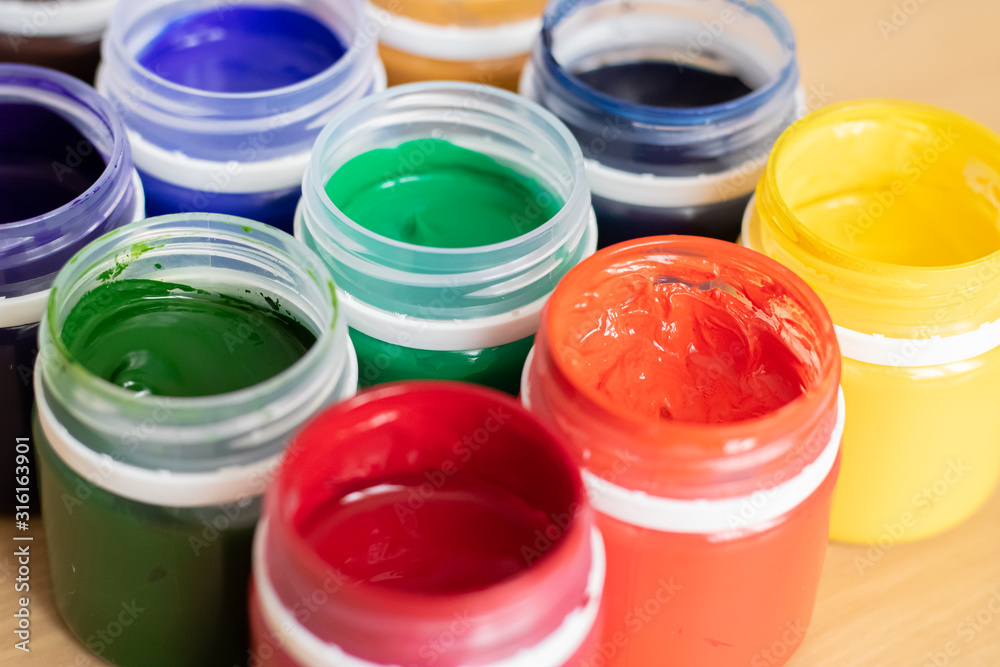 Paint brushes and watercolor paints, tempera paints on the table in a workshop, selective focus, close up, on wooden background. Paint brushes and watercolor paints, tempera paints on the table in a workshop, selective focus, close up, on wooden background.