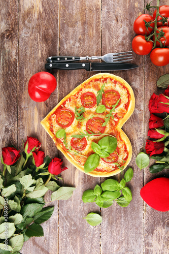 pizza Heart shaped margherita with tomatoes and mozzarella vegetarian. Food concept of romantic love pizza for Valentines Day.