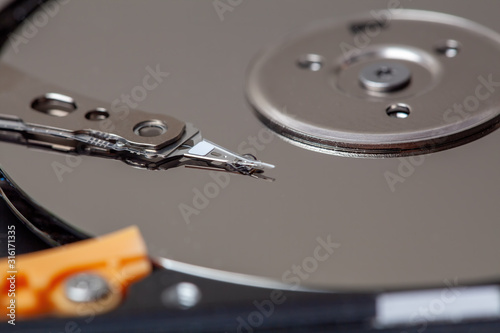 Extreme closeup of mechanic components of a hard drive - magnetic disc called platter and reading head