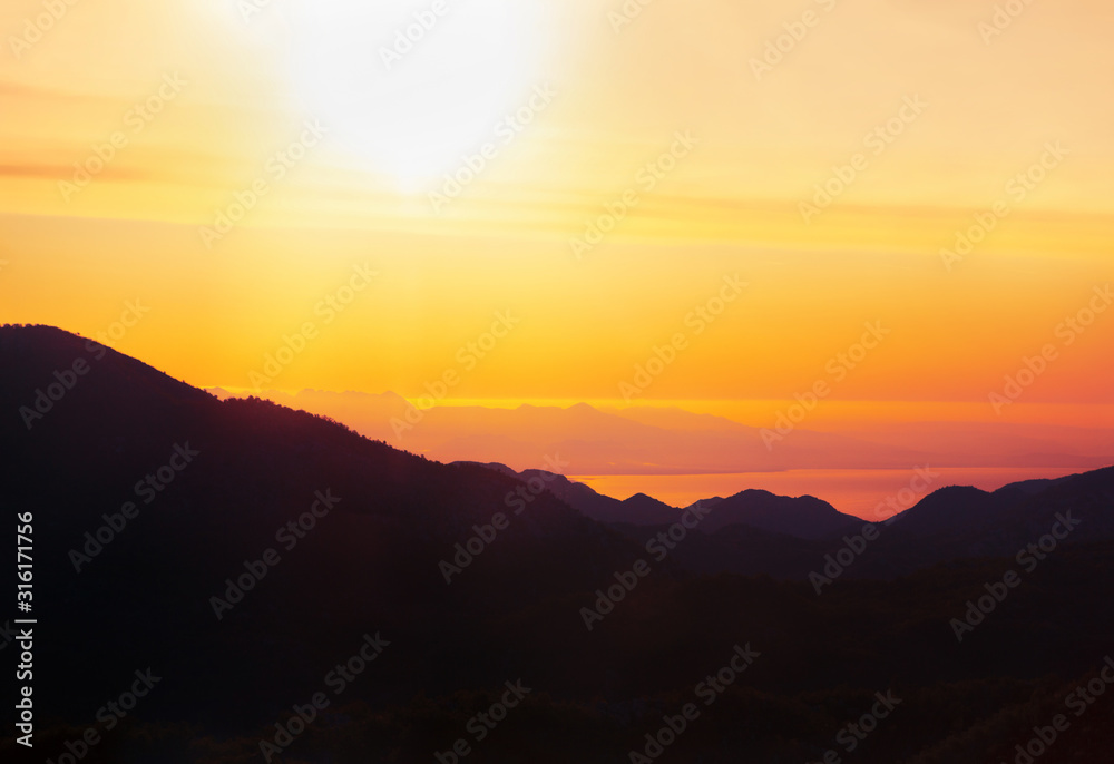 scenery with morning sun over the sea and mountains