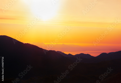 scenery with morning sun over the sea and mountains