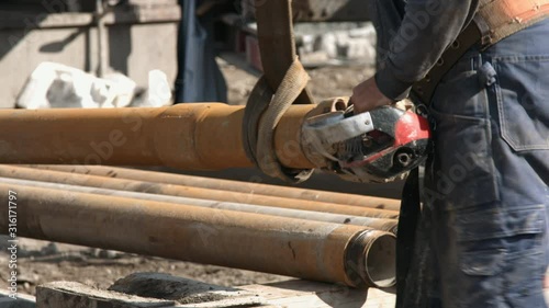 Worker preparing to install drill pipe with tungsten tricone bit to drilling rig photo