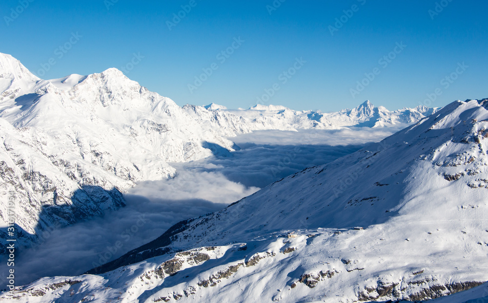 Matter valley and snowy mountains sunset view winter landscape Swiss Alps light clouds in the valley
