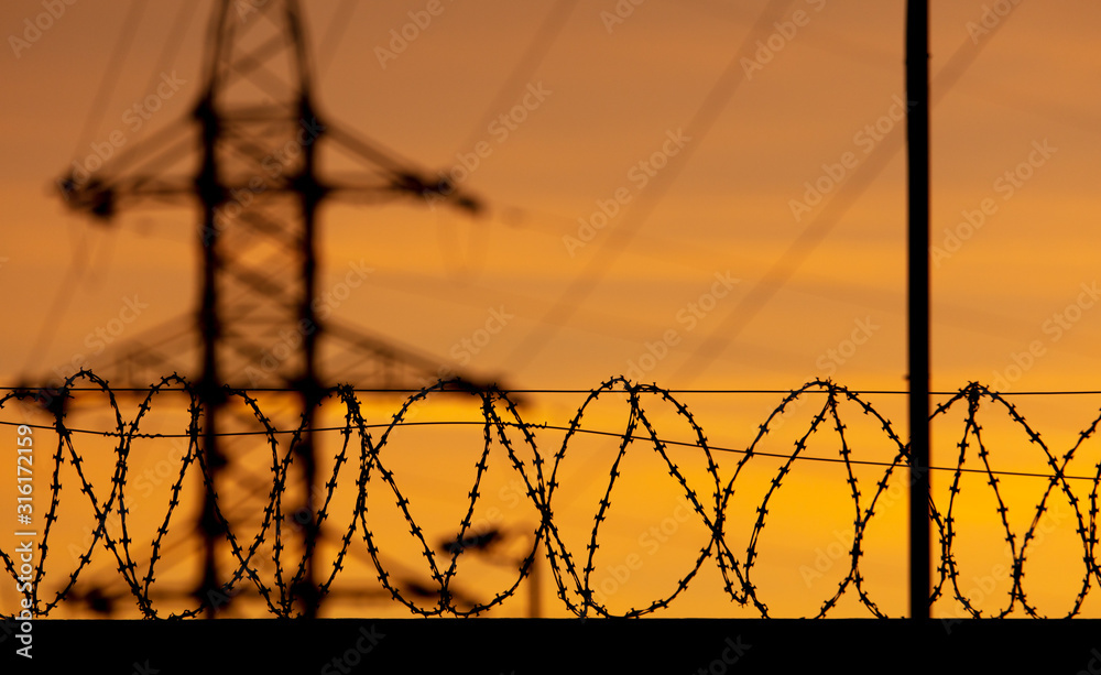 barbed wire on the fence against the backdrop of the sunset. barbed wire on the fence against the backdrop of the sunset.