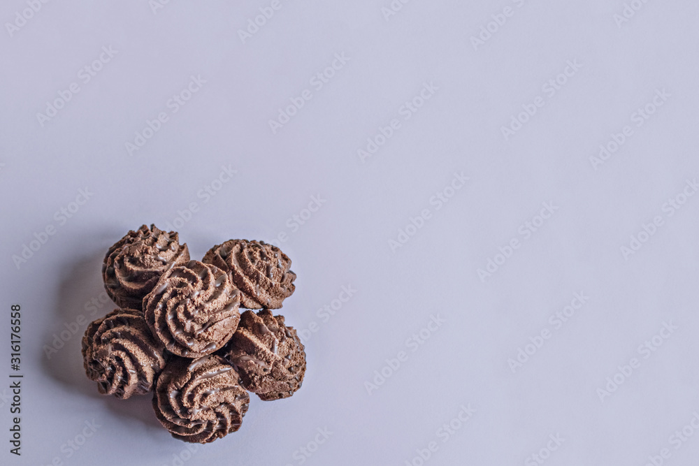 Chocolate delicate cakes on a lilac background. Sweet dessert. Chocolate delicate cakes on a lilac background. Sweet dessert.