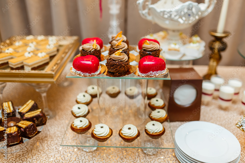 Candy bar on wedding ceremony with a lot of different modern desserts, cupcakes, sweets with fruits. Delicious candy bar. Catering Concept. selective focus