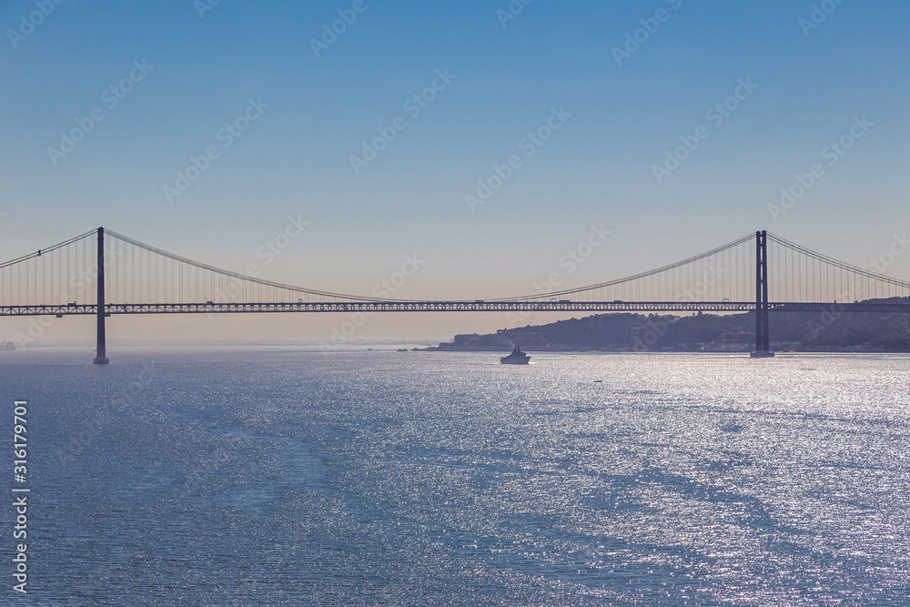 Panoramic view of the 25 de abril bridge over the Tagus River in Belem, Lisbon on a summer day