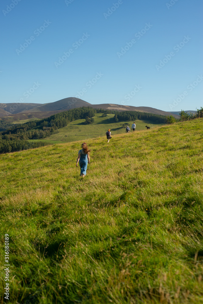 Family With Dog Walk in the Hills in Scotland on a Sunny Day in Summer