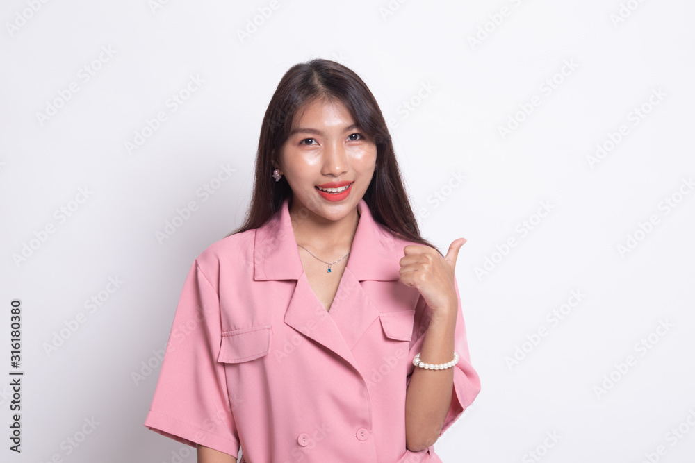 Young Asian woman smile and point to copy space with her thumb. Young Asian woman smile and point to copy space with her thumb.