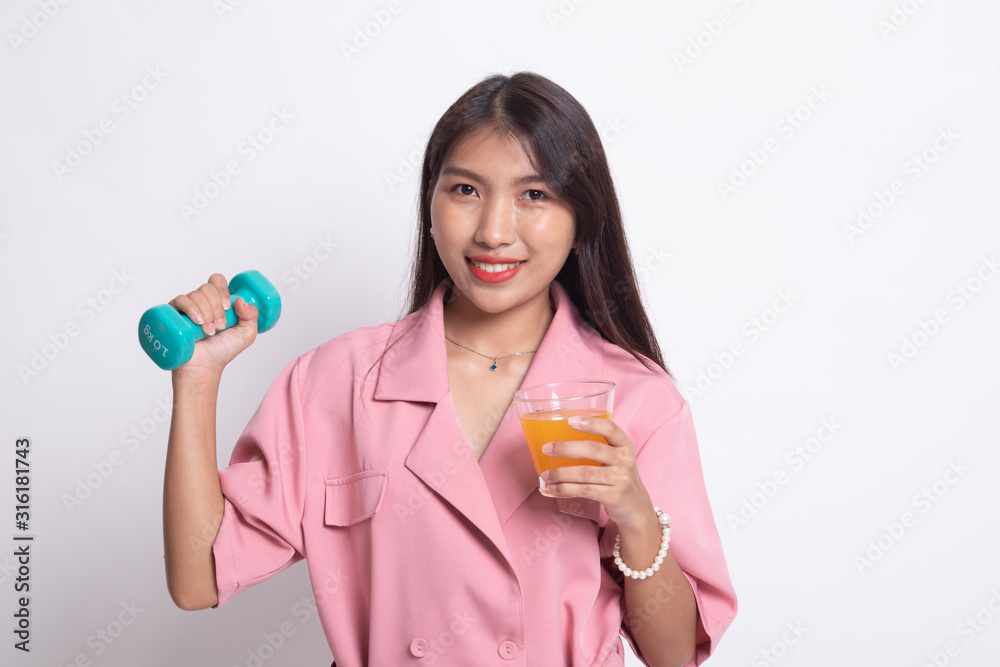 Young Asian woman with dumbbell drink orange juice. Young Asian woman with dumbbell drink orange juice.