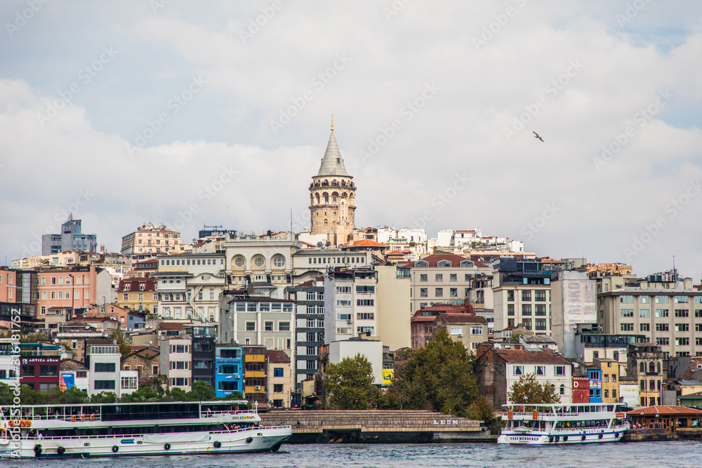 Tourist ship sails on the Golden Horn, Istanbul, Turkey. Scenic sunny panorama of Istanbul city in summer. Beautiful waterfront of Istanbul at sunset. Concept of traveling and vacation in Istanbul.