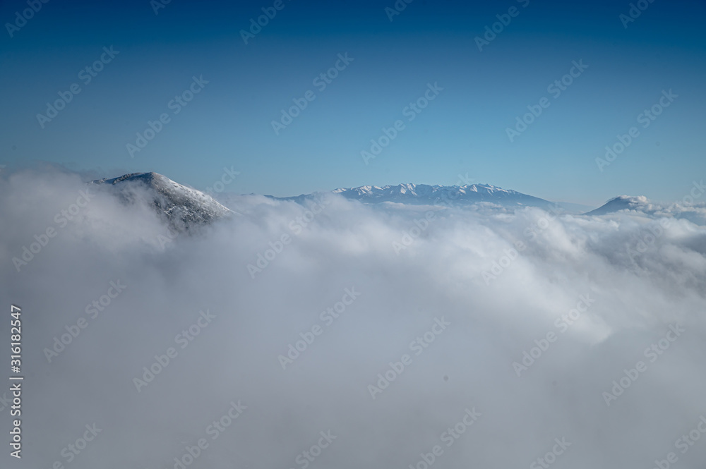 Clouds in winter mountains. Landscape photo, edit space