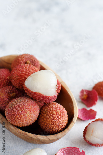 Fresh litchi fruits in a bowl in a white table photo