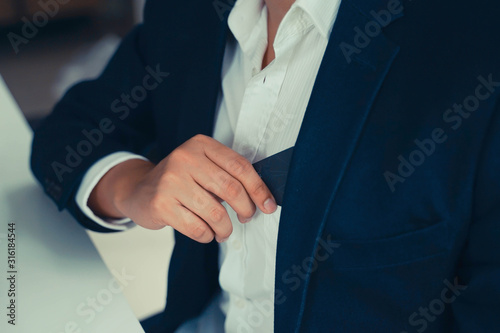 Business man is putting his nme card in his shirt pocket.