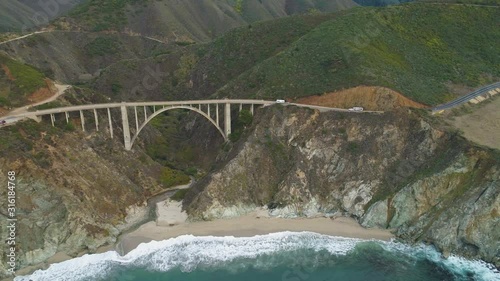 RV on Bixby Creek Bridge. Pacific Coast Highway and Ocean. Big Sur, California, USA. Aerial View. Drone Flies Sideways