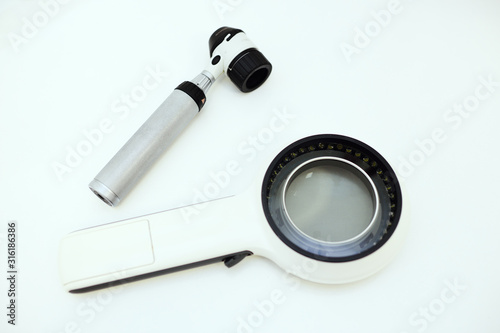 dermatological instruments for examination of moles, birthmarks-Dermatoscope and electronic magnifying glass close-up on a white background. Prevention of melanoma photo