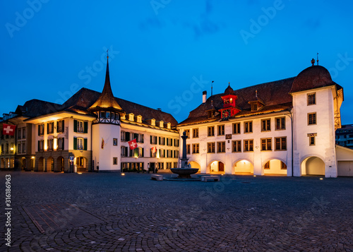 Picturesque nightscape of illuminated buildings and town hall of Thun, Switzerland