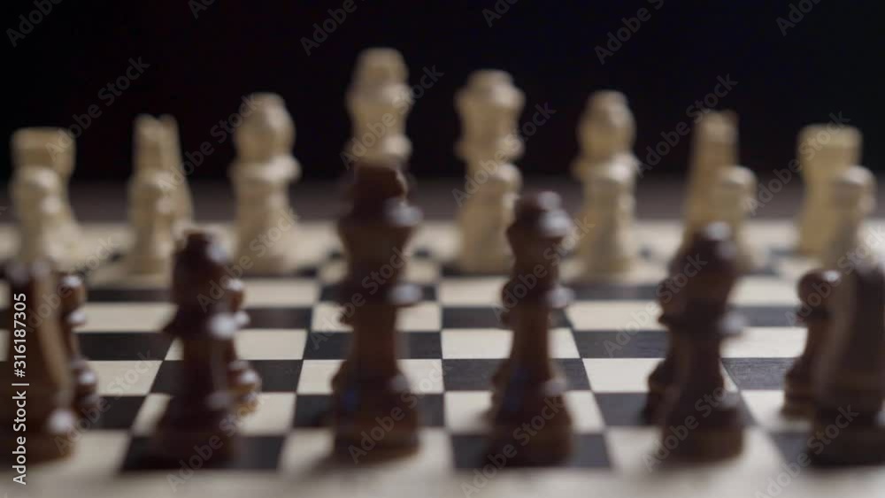 change of focus with the movement of the camera white chess against the background of black chess on a mirrored chessboard on a black background shallow depth of field change of focus with the movement of the camera white chess against the background of black chess on a mirrored chessboard on a black background shallow depth of field