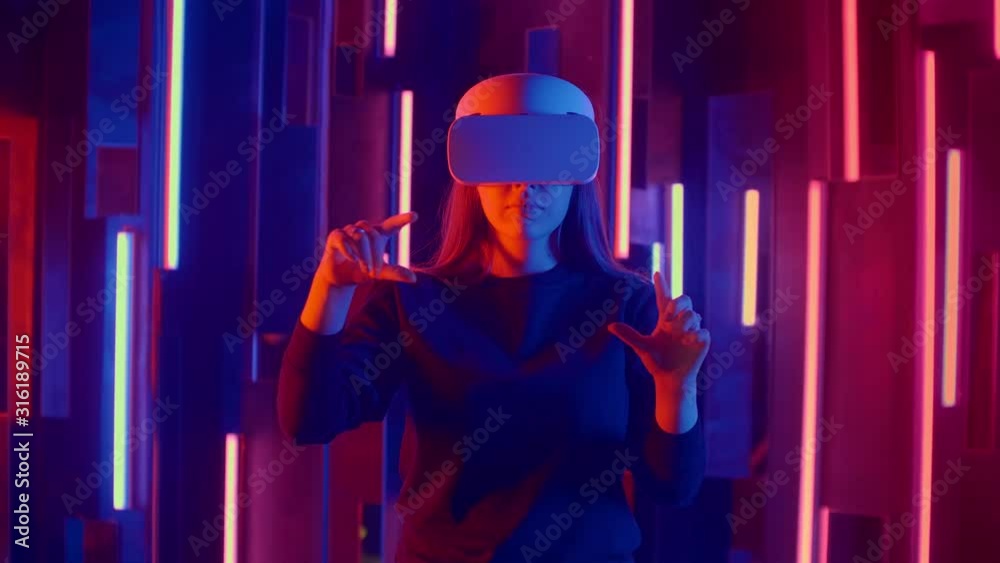Young woman in VR headset looks around and wonders how amazing. Virtual reality helmet. Young woman in VR headset looks around and wonders how amazing. Virtual reality helmet.