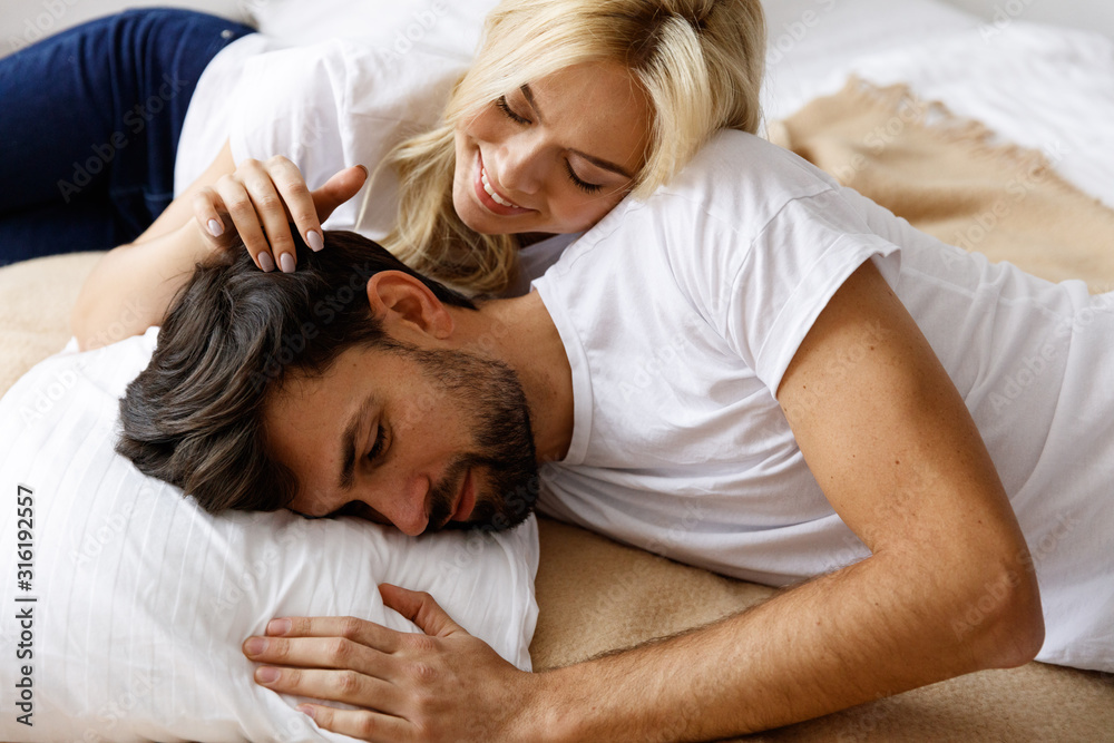 Living together. Love. Fun. Emotions. Young couple have conflict in the bad. Impotence. Happy wife and sad husband. Living together. Love. Fun. Emotions. Young couple have conflict in the bad. Impotence. Happy wife and sad husband.