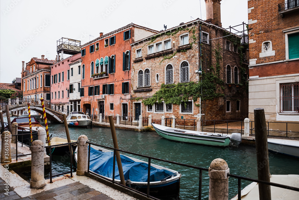 canal, motor boats and ancient buildings in Venice, Italy