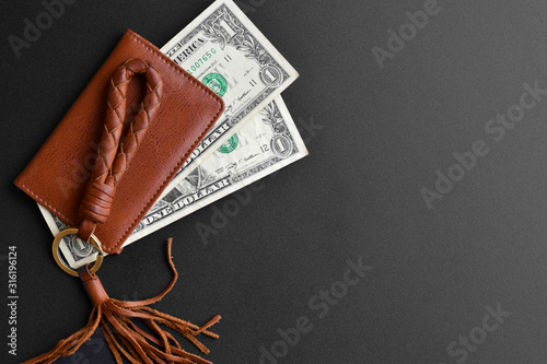 High angle view, Brown leather wallet with dollar cash on black background.