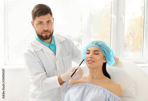 Plastic surgeon applying ma...