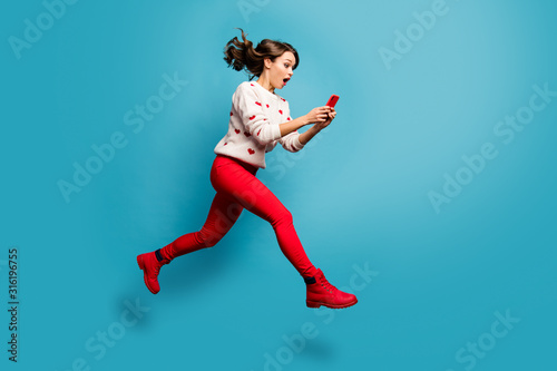 Full length body size view of nice attractive cheerful amazed impressed girl jumping using 5g like follow subscribe running hurry rush isolated on bright vivid shine vibrant blue color background