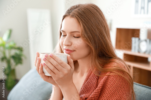Fototapeta Naklejka Na Ścianę i Meble -  Happy woman with cup of tea resting at home